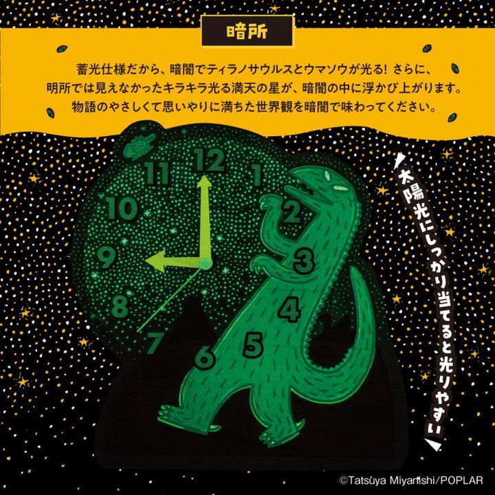暗闇で緑色に光るティラノサウルスと星が描かれたアクリル時計のアップ