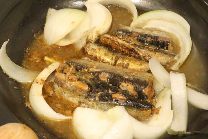 フライパンでいわし醤油煮と玉ねぎを煮込んでいる