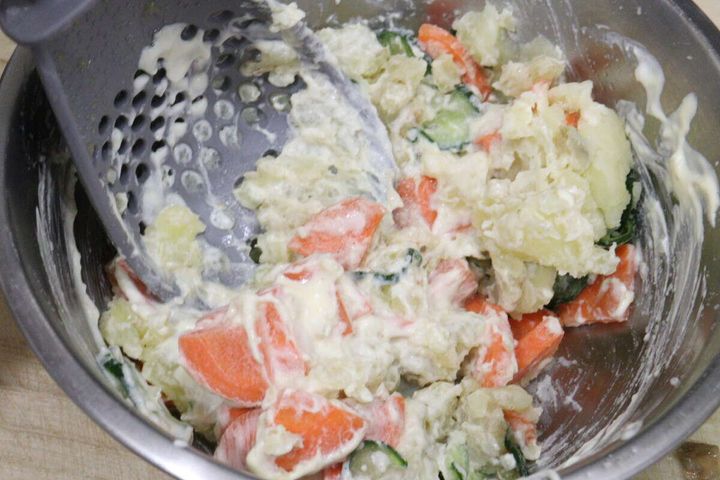 ボウルに入ったポテトサラダを多機能ざるスプーンで混ぜている。