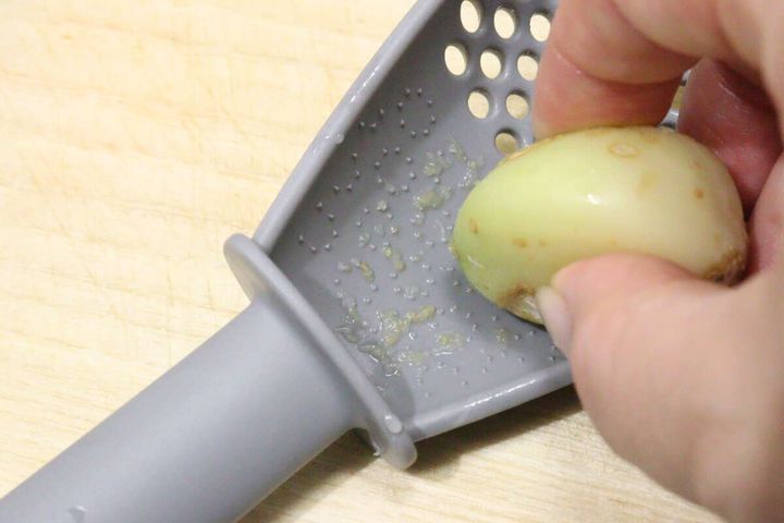 多機能ざるスプーンの裏面でニンニクをすりおろす手元。