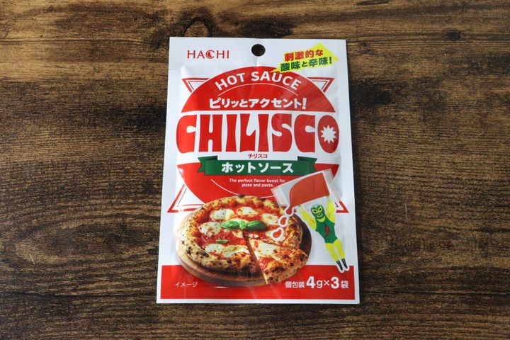 木目のテーブルに置かれたチリスコホットソースのパッケージ