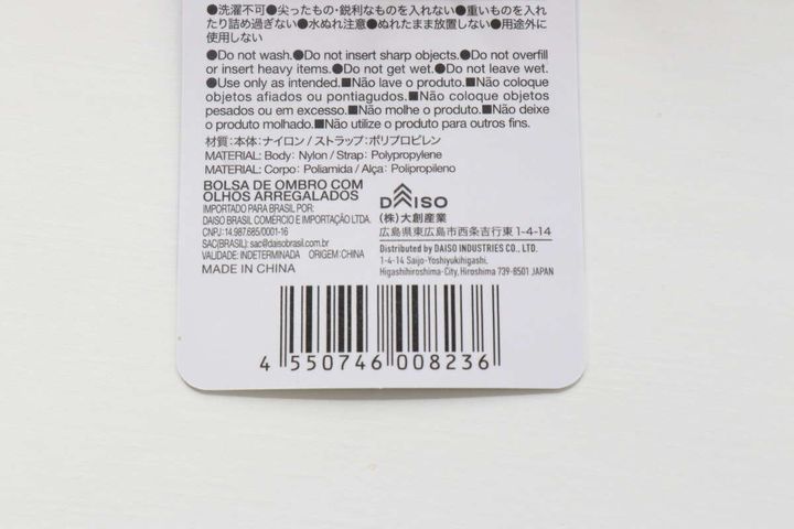 グレーのギョロ目ショルダーバッグに付いている商品情報タグ。