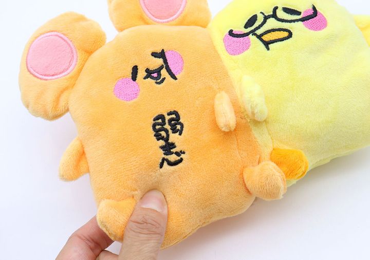 女性がなぴめと弱き心のぬいぐるみチャームを片手で持っている