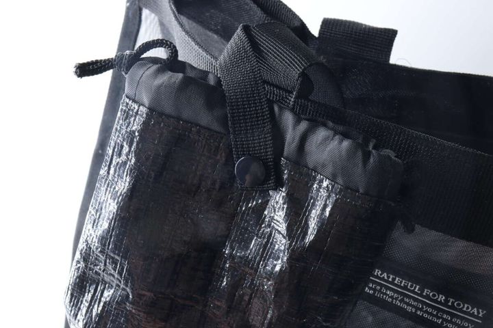 黒い携帯ゴミ箱を黒いバッグの持ち手にスナップボタンで取り付けている