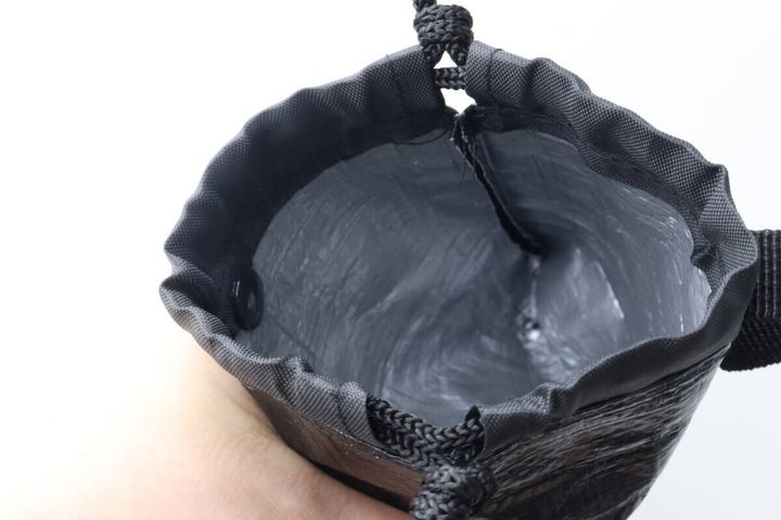 黒い携帯ゴミ箱のドローコードを開けて中を覗き込んだ様子