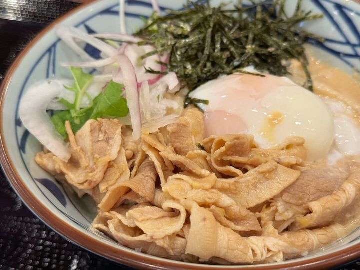 うどんの上には、豚しゃぶ、シャキシャキの野菜、温玉が贅沢に盛られています