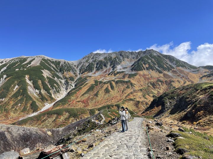 石畳の遊歩道と紅葉した岩山の谷