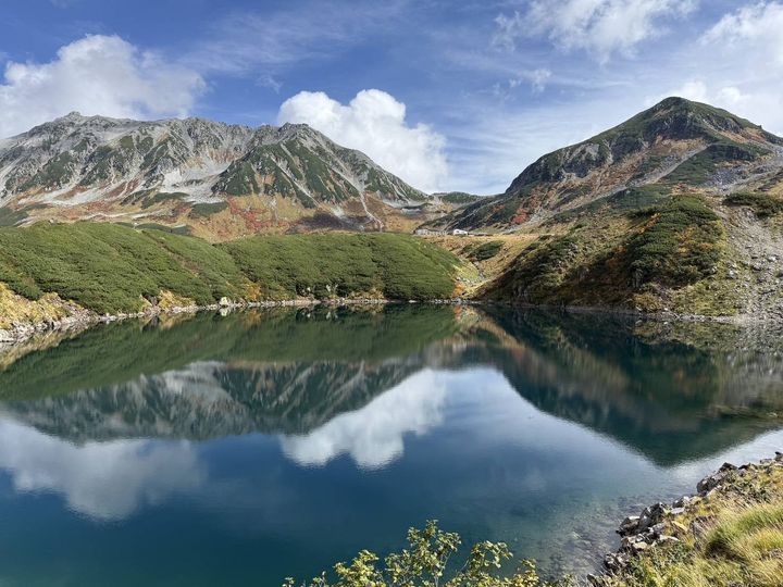 みくりが池に立山連峰と雲が映り込む紅葉風景