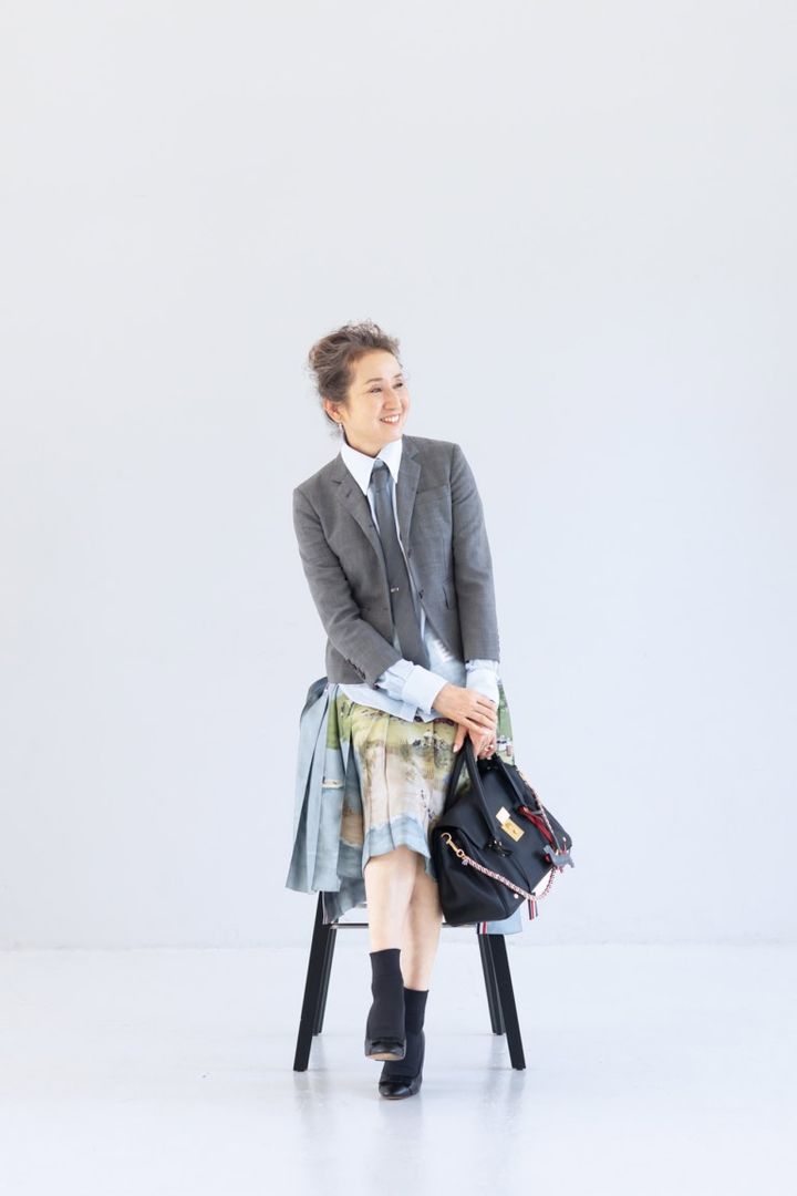 ネクタイ¥42,900、ネクタイピン¥70,400、ジャケット¥281,600、シャツ¥138,600、スカート¥493,900、バッグ¥753,500、犬のチャーム各¥64,900、シューズ 参考商品／すべてトム ブラウン（トム ブラウン ジャパン）、ピアス（右耳）¥121,000、重ねたリング（指先から）¥162,800、¥200,200 ／すべてヒロタカ（ヒロタカ表参道ヒルズ）、ソックス／スタイリスト私物