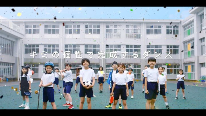 校庭に並ぶ子どもたちと「キミの個性で完成するダンス」のメッセージ