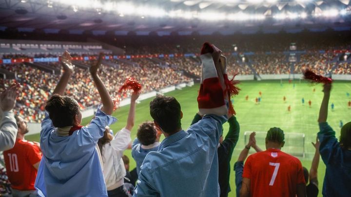 サッカーの試合をスタジアムで観戦する人々