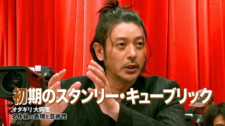 赤いカーテンを背景に語るオダギリジョー