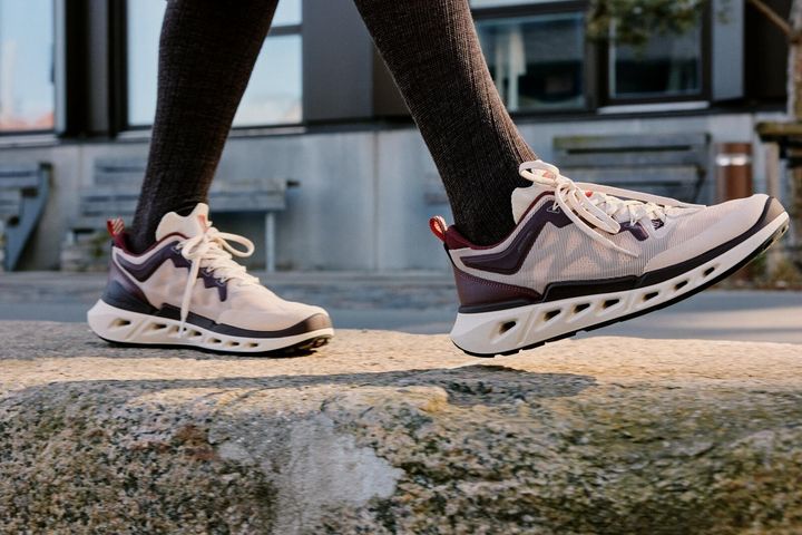 ECCOニットメッシュスニーカーを履いて歩く人物の足元