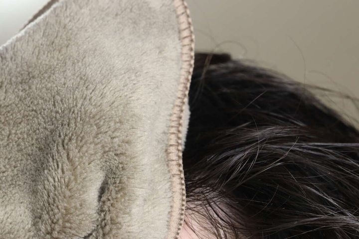 茶色のヘアドライタオルで濡れた髪の毛を拭いている様子