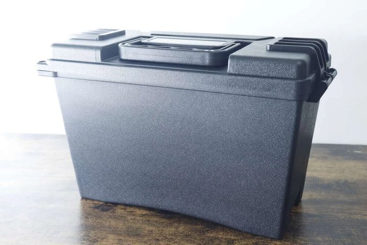 黒い防滴工具箱が木目調のテーブルに置かれている