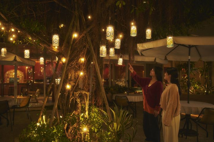 木々に吊るされた紅型デザインのランタン