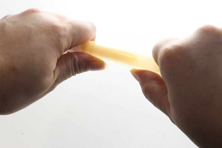 女性の両手がライトスティックを中央で折る様子