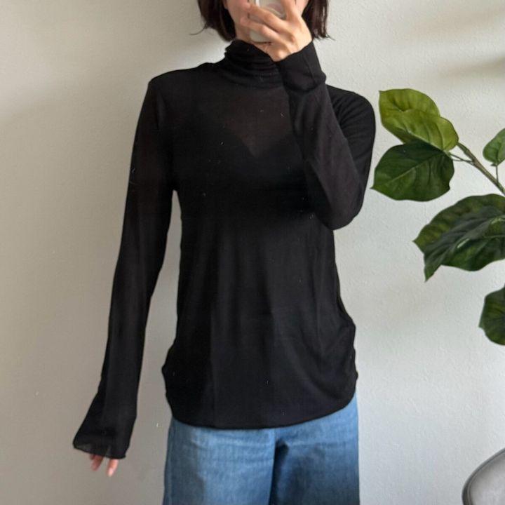 黒のタートルネックTとデニムを着用した女性