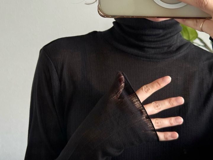 黒タートルネックTの透け感と長めの袖口のアップ