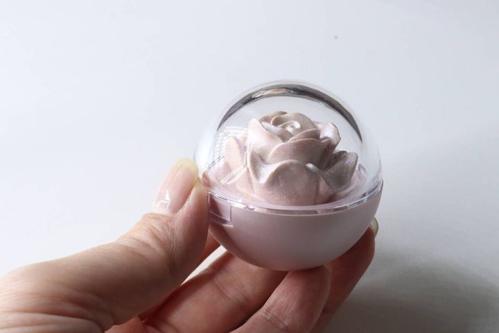 女性の手がバラ型ハイライターのケースを持っている