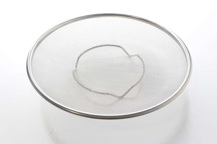 商品パッケージが外されたステンレス製の浅型ザルを真上から撮影