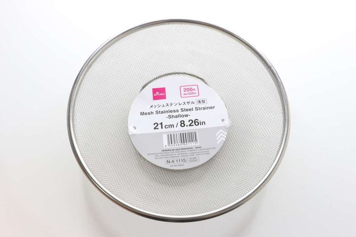 商品パッケージが貼られたステンレス製の浅型ザルを真上から撮影