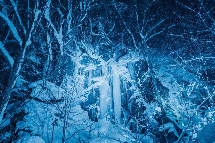 氷瀑 青い照明に照らされた氷柱と岩肌