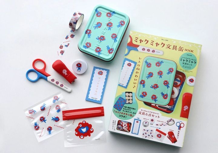 ミャクミャク文具缶BOOKの表紙と、缶ケース、文具6点が広げられた状態