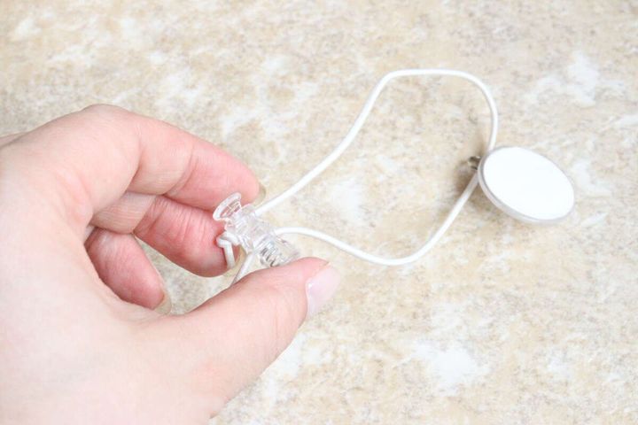 白いゴム紐のドローコードを指でつまんで長さを調整している手元のクローズアップ