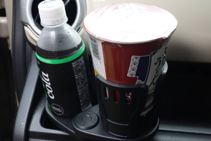 車のドリンクホルダーに設置された商品にペットボトルとカップ麺が置かれている