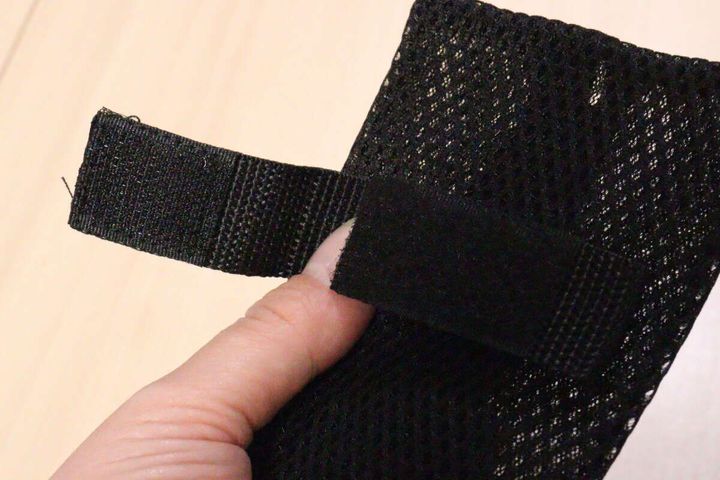 ポーチの裏側にある面ファスナーを指で開いて見せている様子