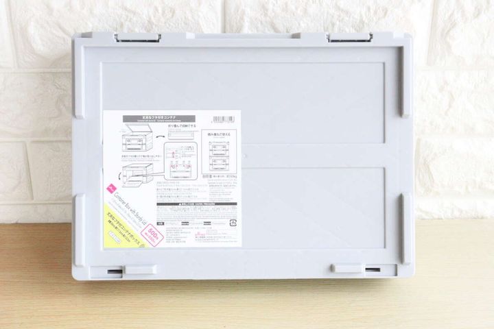グレーの折りたたみコンテナボックスの裏面、商品情報シールが貼られている