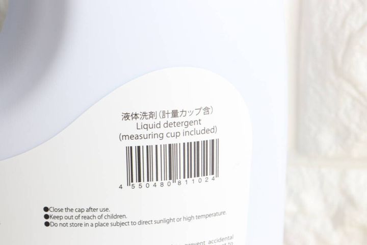 白い液体洗剤ボトルの側面にある、商品名とバーコードが書かれたシール部分のクローズアップ