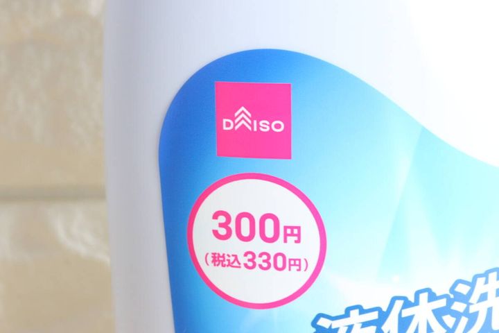 白い液体洗剤ボトルのラベルに書かれた「DAISO」ロゴと「300円（税込330円）」の価格表示部分のクローズアップ