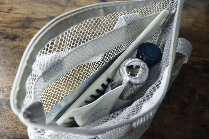 グレーのスパバッグに洗面用品が収納されている