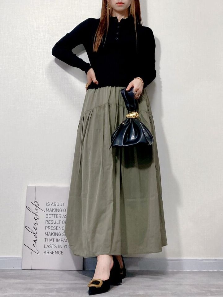 黒のポロニットとカーキのロングスカートを着用した女性の全身コーデ