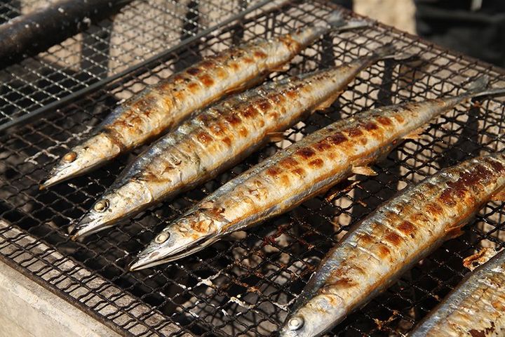 炭火グリルで焼かれるサンマ