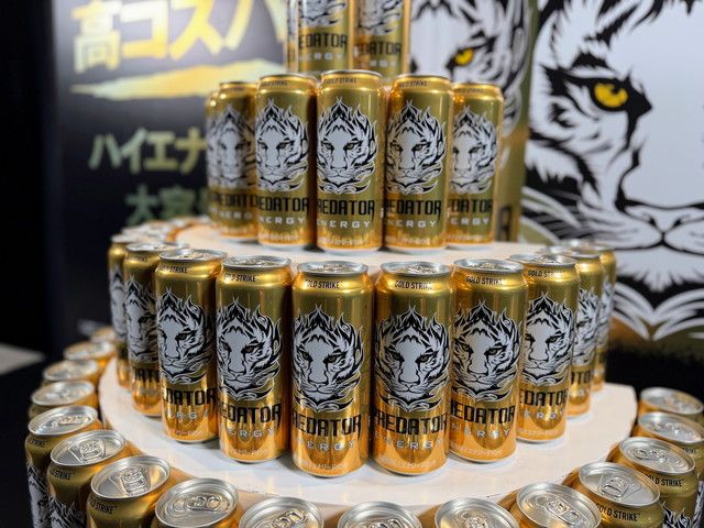 タワー状に並べられた『プレデターエナジー』の缶と、白いトラが描かれたゴールドのパッケージ