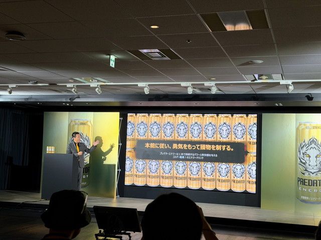 「本能に従い、勇気をもって獲物を制する。」と映し出されたスクリーンの前で講演するアサヒ飲料の登壇者