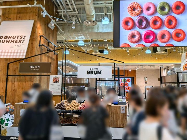 『DONUTS SUMMER どーなつまつり！2026』が開催されている阪神梅田本店の食祭テラス。行列ができて、多くのお客さんで賑わっています。