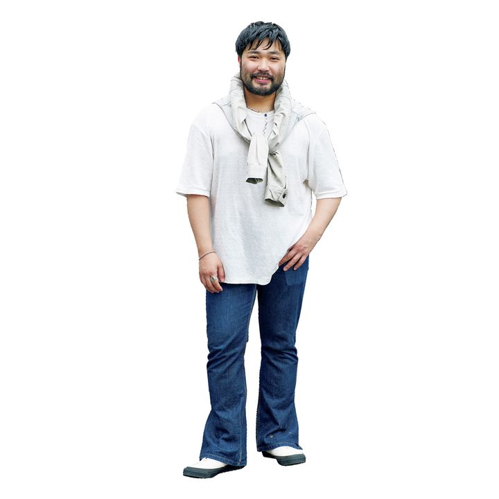 Tシャツとデニムにジャケットを肩掛けしたÉDIFICEバイヤーの三浦凛太郎さん