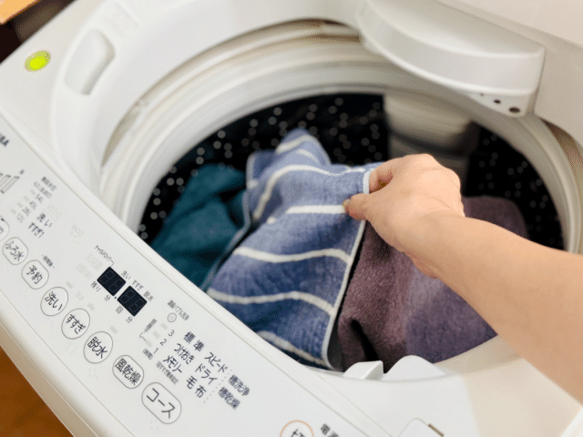 洗濯機に洗濯物を入れる
