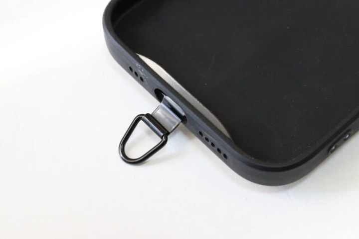 スマホケースの充電口からストラップホルダーが出ている