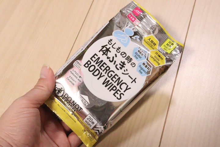 女性の手がダイソー体ふきシートのパッケージを持つ