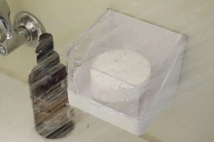 浴室の壁に設置されたフタ付きケースにシャワーの水がかかっている