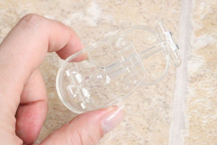 透明なぬいぐるみスタンド本体を指でつまむ