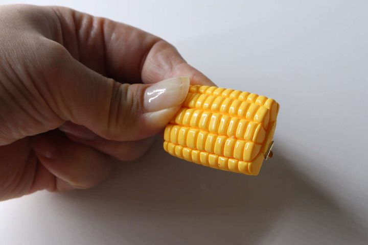 とうもろこし型ヘアクリップを指でつまんで見せている様子