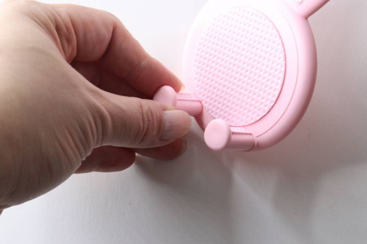 指でウサギの顔部分にスマホのストッパーパーツを取り付けている様子