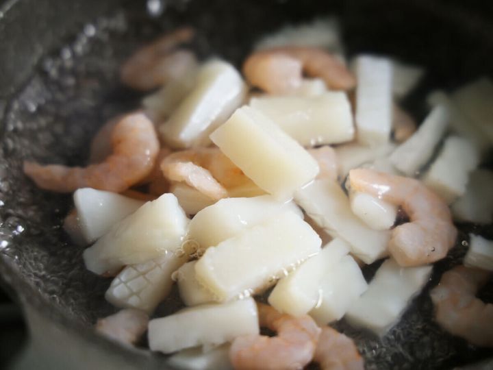 鍋で沸騰したお湯でシーフードミックスを茹でている様子