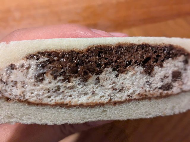 クランキー＆ホイップサンドの断面。パフ入りのチョコソースとチョコ入りホイップクリームの2層になっている